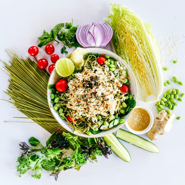 Stoke Salad's vegetarian bowl with green noodles, edamame, tomatoes, and shredded plant-based protein.